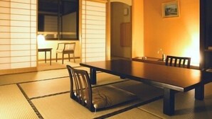Une pièce de style japonais traditionnel, avec un sol recouvert de tatamis, une table basse et des chaises.