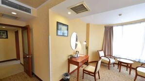 A hotel room with a desk, chair, and a large window with curtains. - Beijing RJ Brown Hotel (Beijing)