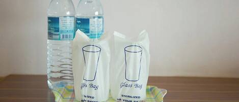 Dos botellas de agua y dos bolsas de vidrio sobre una bandeja.