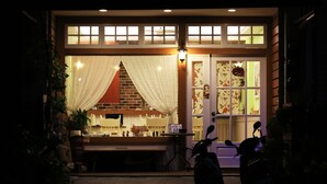 A restaurant with a brick facade, white curtains, and a sign with the number 58. - Snail Trail B&B (Taitung)