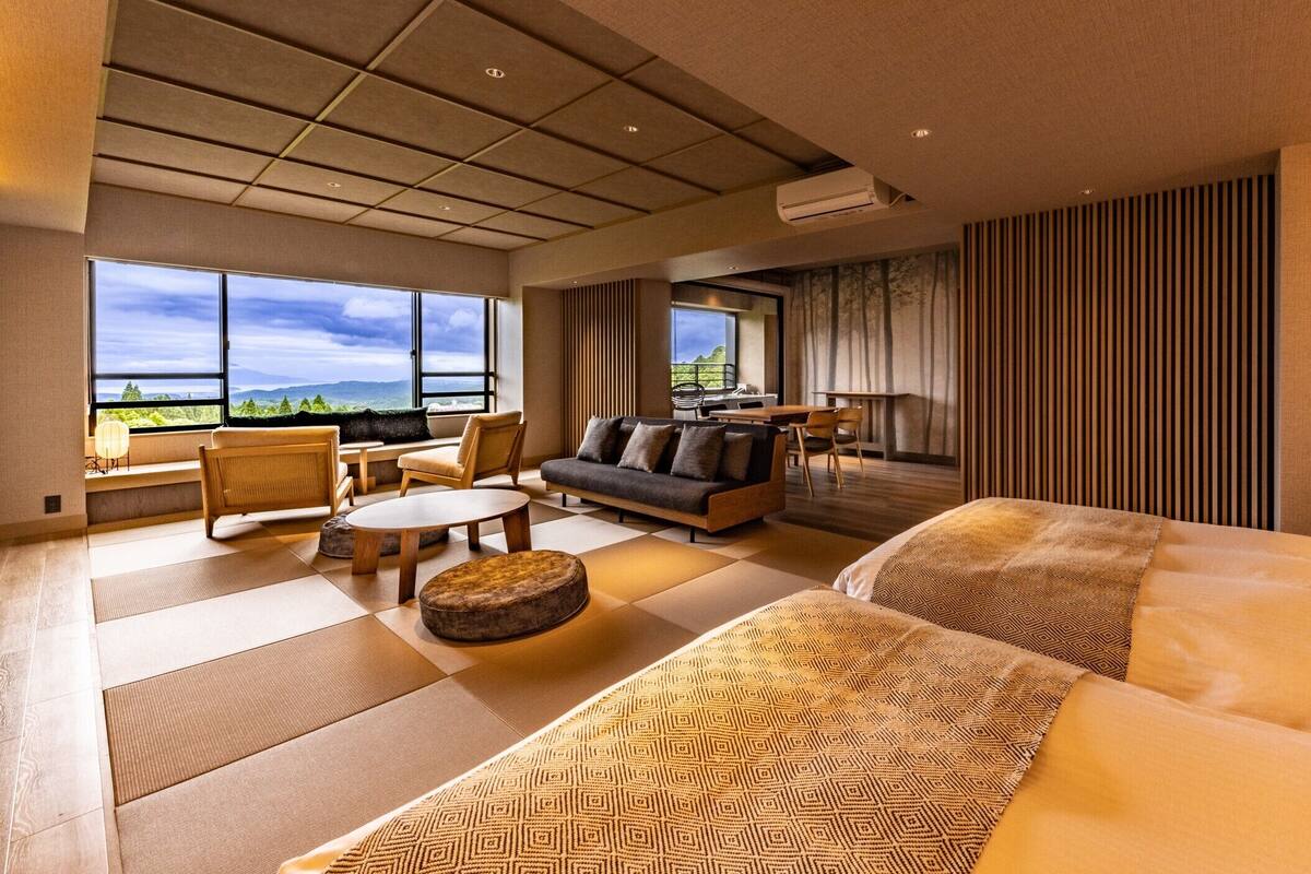 Une chambre d’hôtel avec un grand lit, un canapé, une table à manger et une vue sur les montagnes.