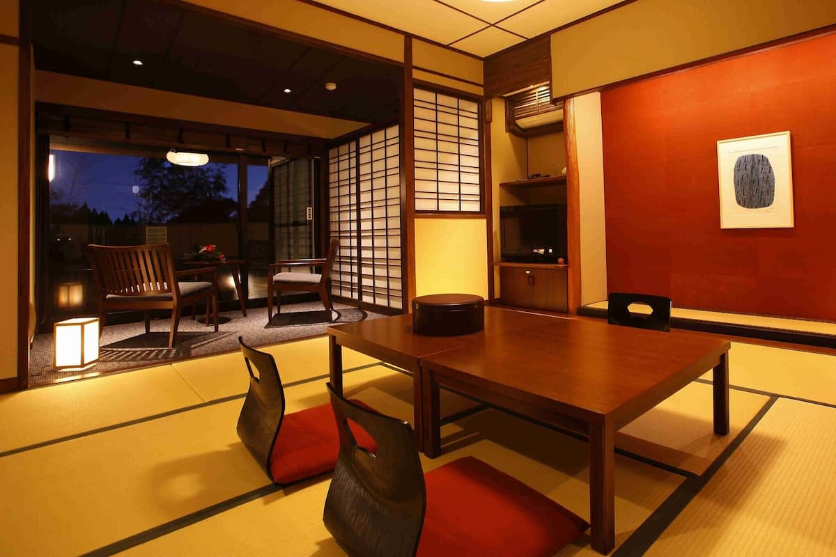 Una habitación japonesa tradicional con suelo de tatami, una mesa baja y un televisor.