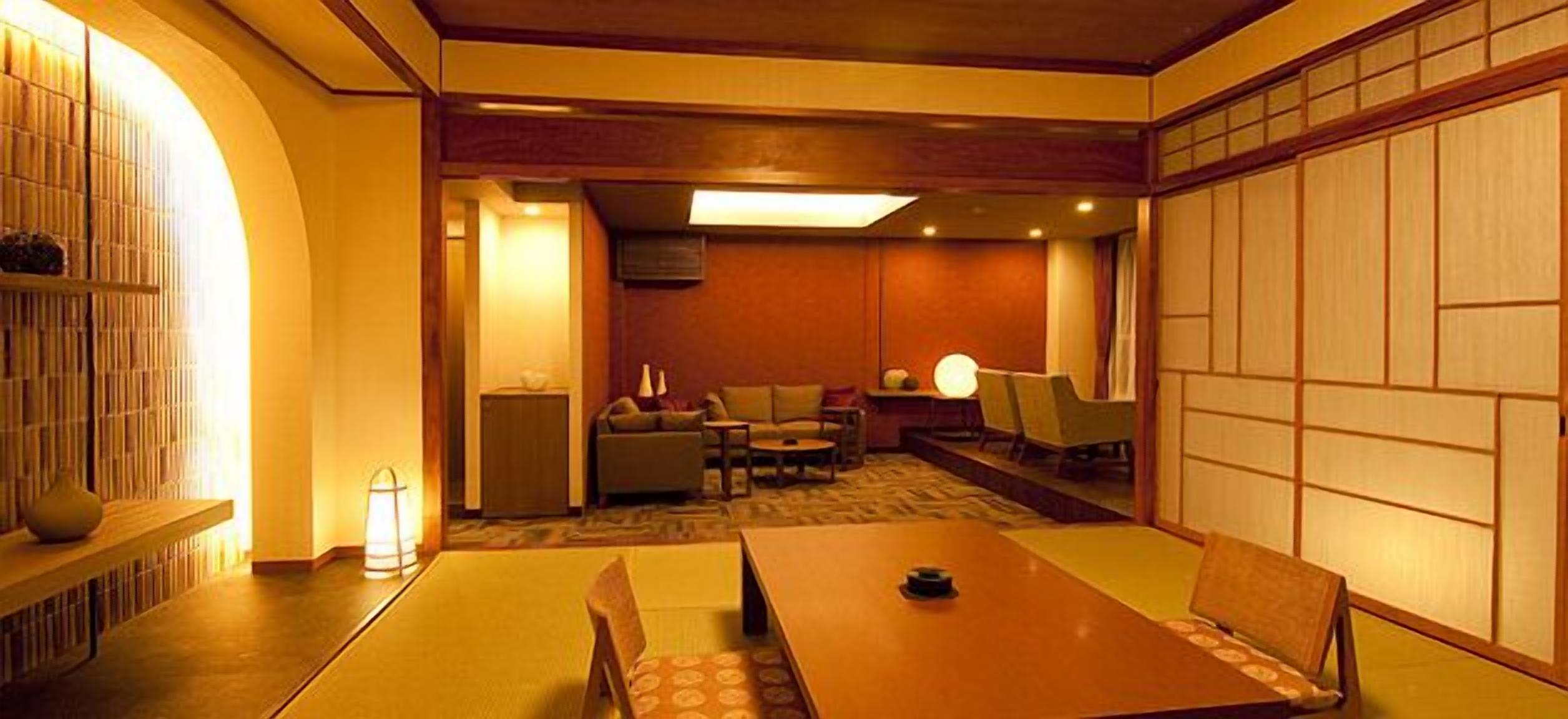 A traditional Japanese-style room with tatami flooring, a low table, and a sofa.