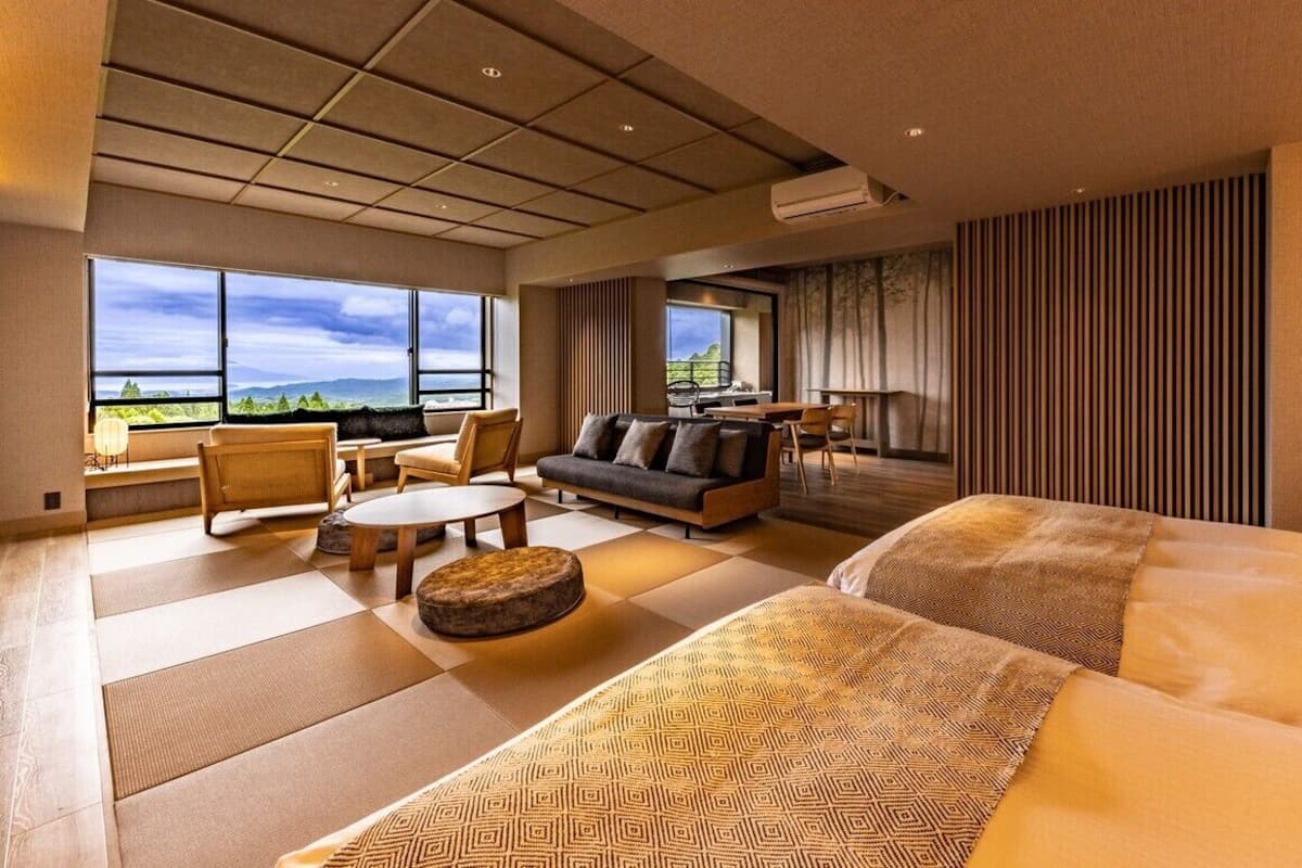 Une chambre d’hôtel avec un grand lit, un canapé, une table à manger et une vue sur l’extérieur.