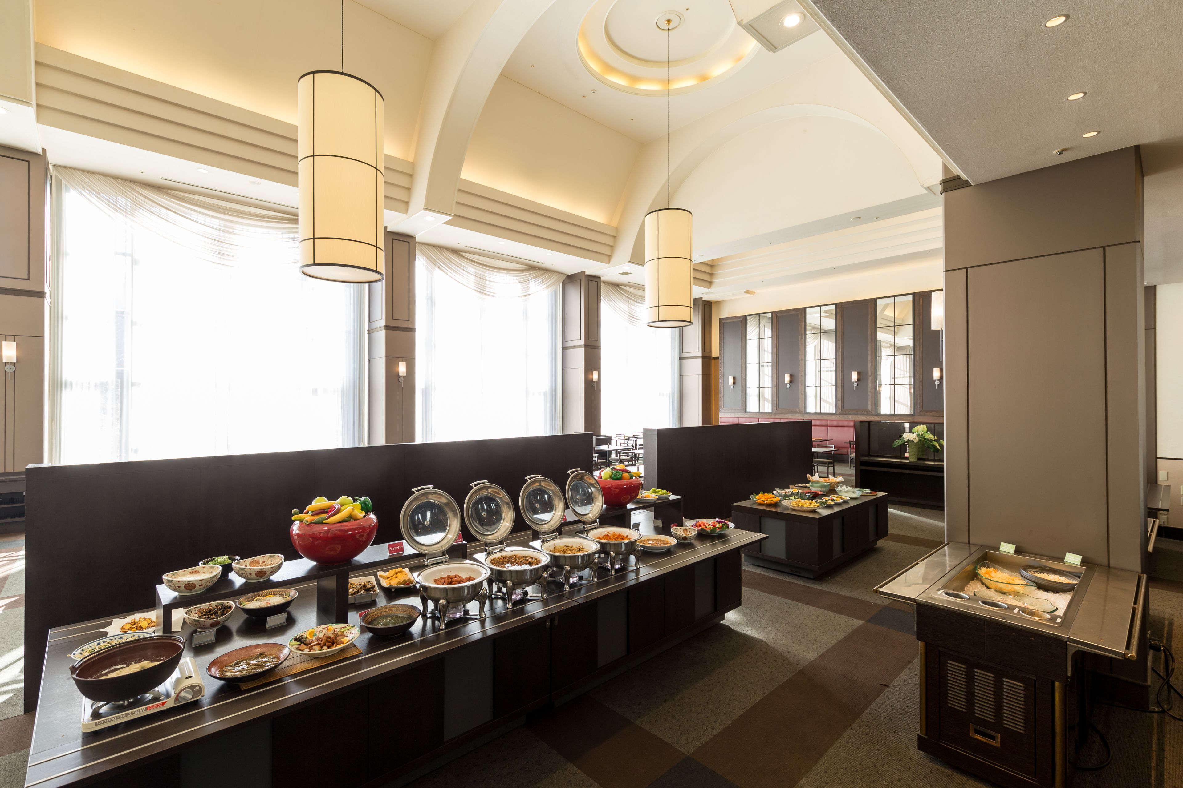 A buffet setup with various food items and a modern interior design.