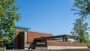 Een modern gebouw met een bord waarop staat: RiverSide Restaurant & Bar.