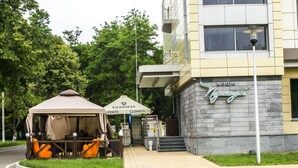 A building with a sign reading "Cafe Nerezgan" and a tented outdoor seating area with "Guinness" branding.