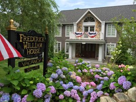 A house named 'Frederick William House' with a sign indicating vacancy and a phone number.