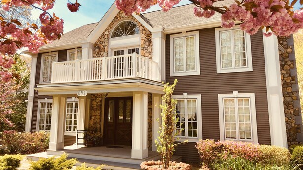 A two-story house with a stone facade, a balcony, and a well-maintained garden. - Frederick William House (Falmouth)