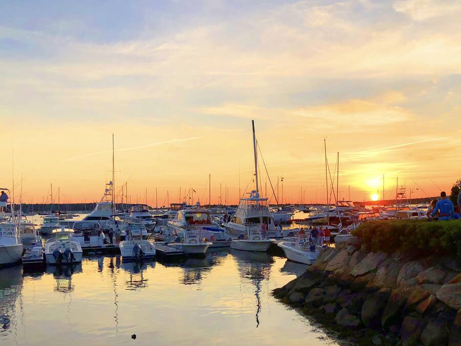 A marina with multiple boats docked at sunset.