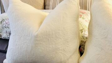 A bed with large white pillows and a floral-patterned blanket.