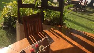 A wooden table with a clear acrylic organizer containing a cactus and a flower.