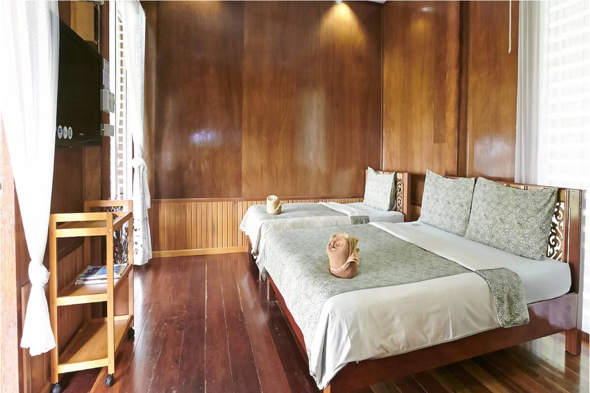 Ein Zimmer mit Holzwänden, einem Bett, einem kleinen Tisch und einem Regal.