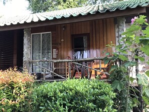 Eine Holzhütte mit Ziegeldach, einer Holzterrasse und einem kleinen Fenster.