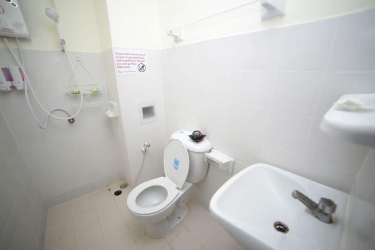 A small, clean bathroom with a toilet, sink, and shower.