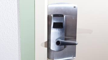 A metallic door handle with a keyhole and a small rectangular slot, likely for a card reader.