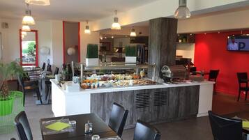 A modern restaurant with a central buffet, dining tables, and chairs.