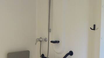 A bathroom with a shower, a towel rack, and a soap dish.