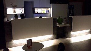 A modern office space with cubicles, a reception area, and a small round table with a sign. - Brit Hotel Rouen Sud / Val De Reuil (Val-de-Reuil)