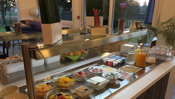 A buffet with various food items and beverages, including fruits, yogurts, and juices. - Brit Hotel Rouen Sud / Val De Reuil (Val-de-Reuil)
