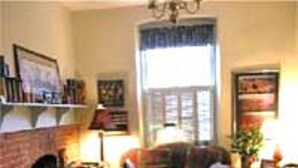 A cozy living room with a fireplace, a sofa set, and a coffee table. - Stone Haus Bed & Breakfast (Hermann)