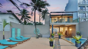 Ein Hotel mit Pool, Liegestühlen und einem Balkon mit Blick auf den Pool.