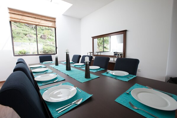 Un comedor con una mesa dispuesta para seis personas, con platos, cubiertos y servilletas.
