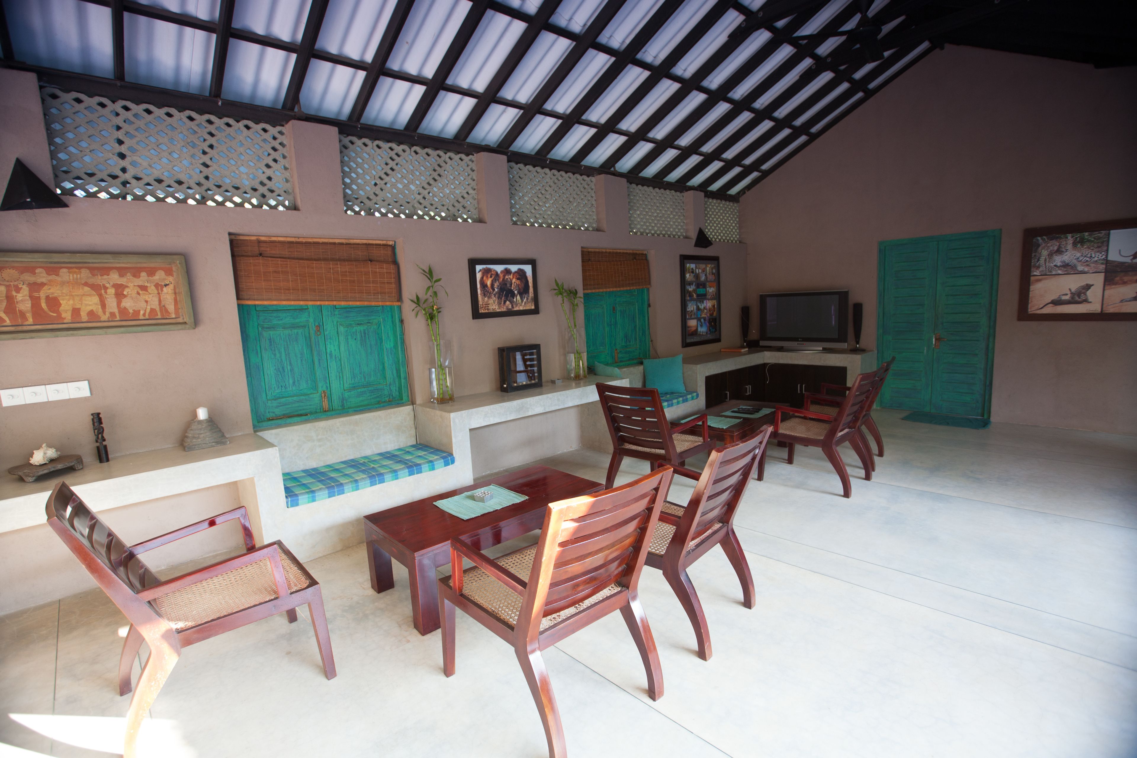 Un comedor con mobiliario de madera, un televisor y detalles decorativos en las paredes.