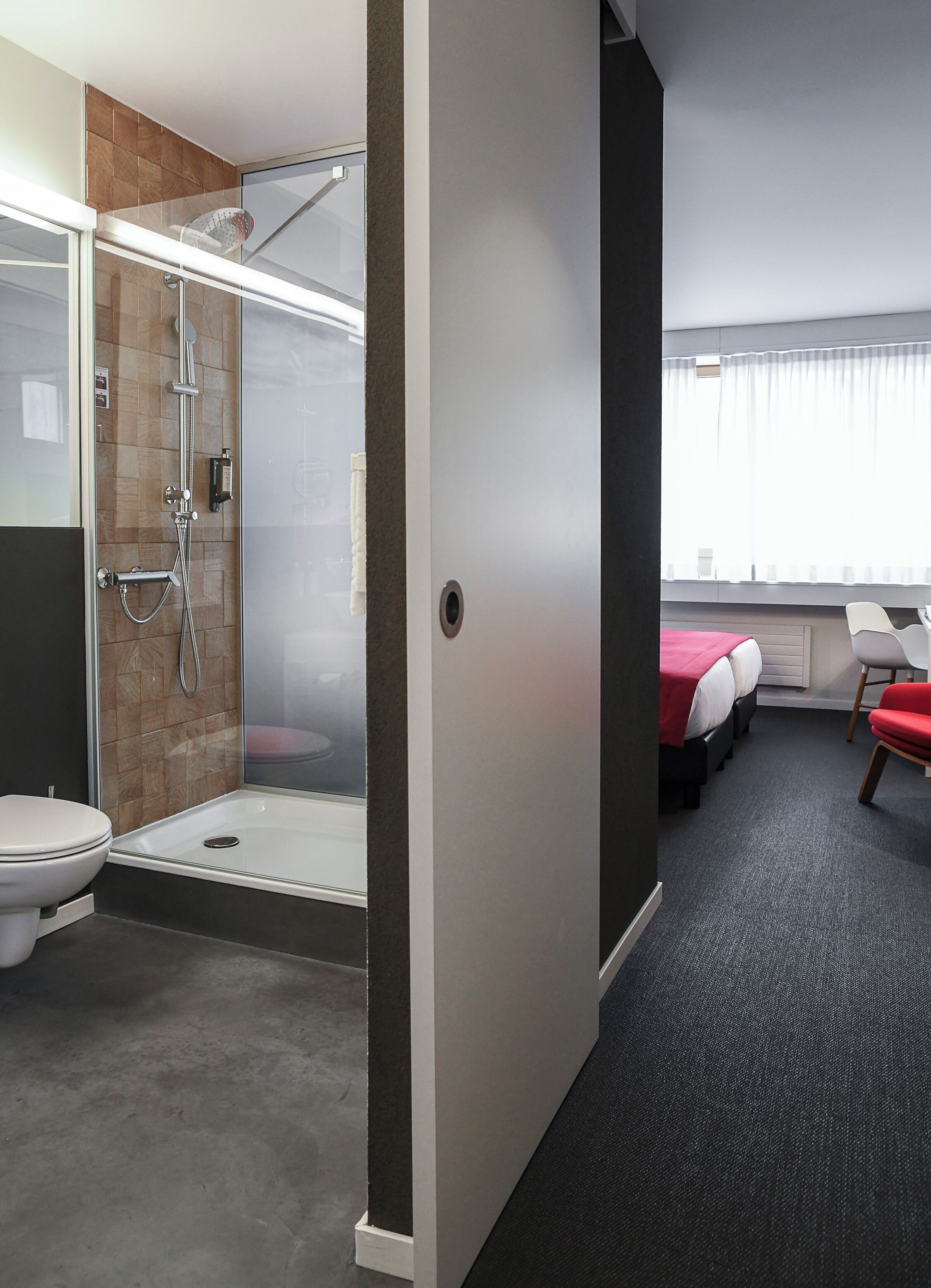 Un baño moderno con cabina de ducha de vidrio, inodoro y lavamanos.