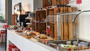 A breakfast buffet with various food items and condiments. - Home Swiss Hotel (Geneva)