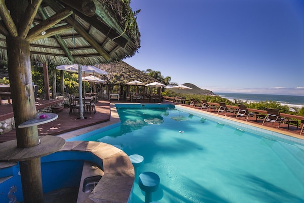 Una piscina al aire libre, sombrillas, tumbonas