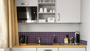 Una cocina moderna con microondas, cafetera y fregadero.