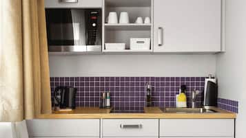 Una cocina moderna con microondas, cafetera y fregadero.