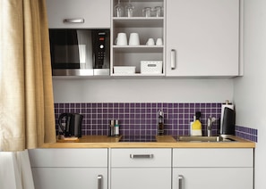 Una cocina moderna con microondas, cafetera y fregadero.