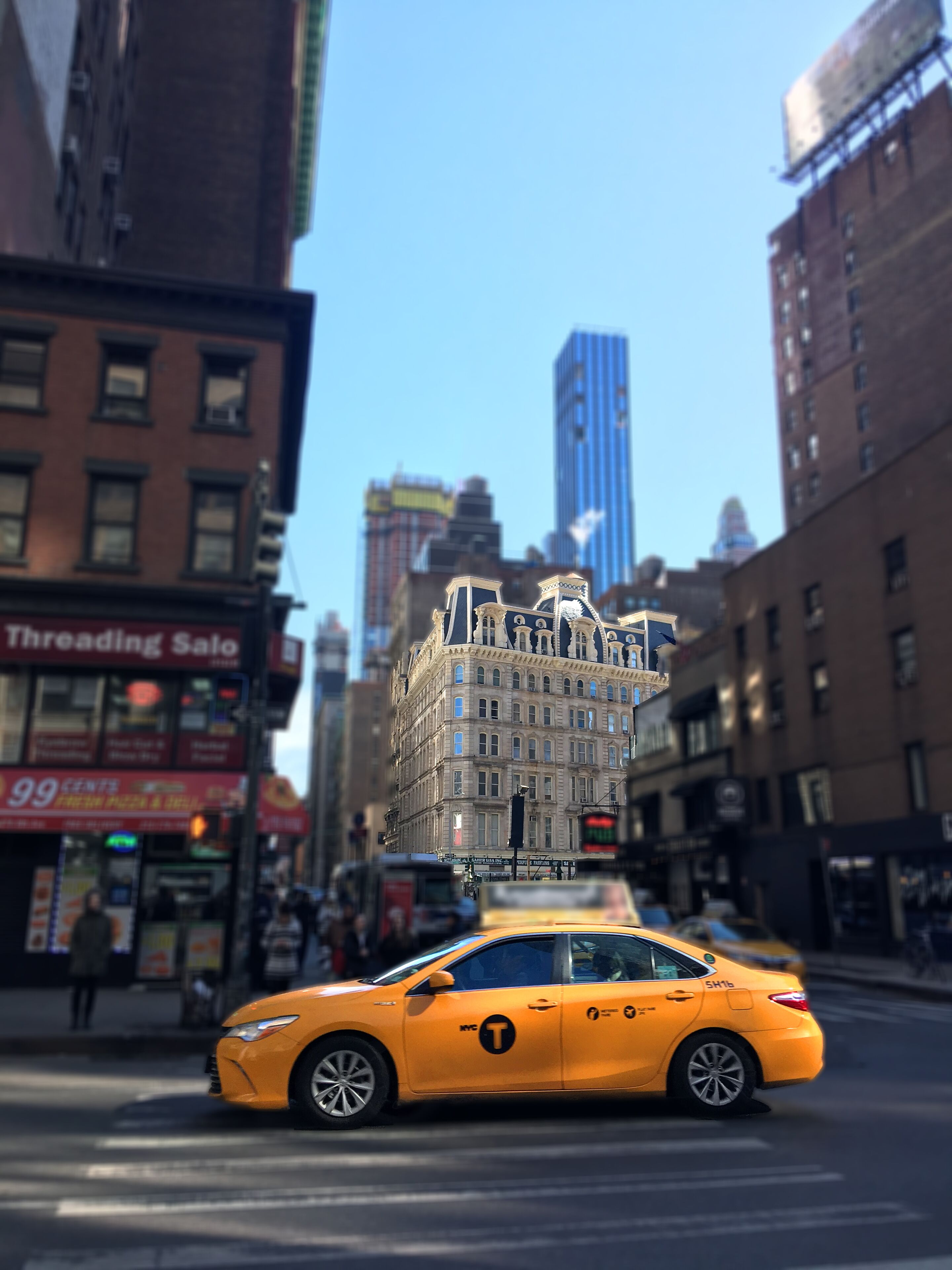 A yellow taxi with a large building on its roof.