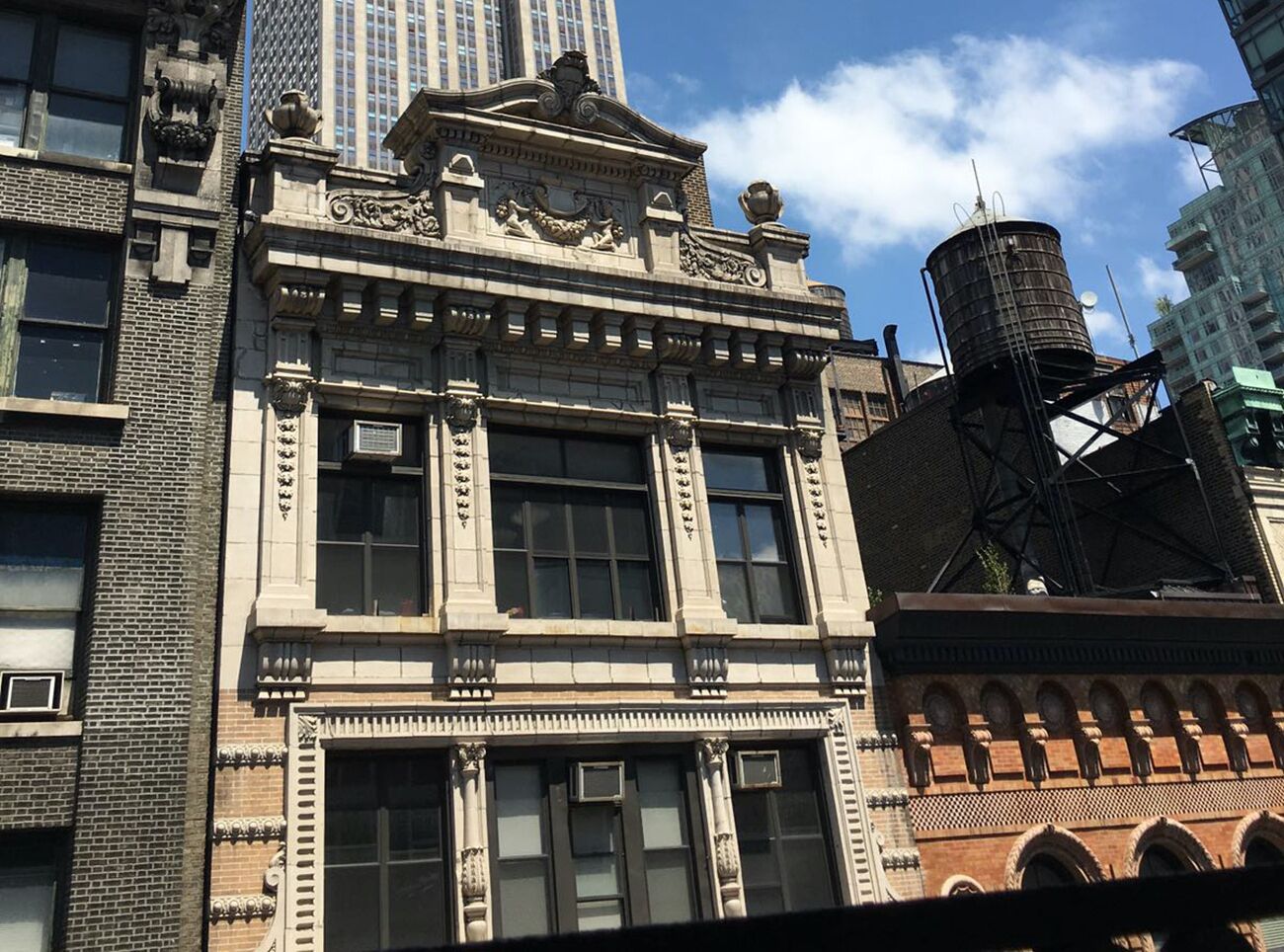 A historic building with ornate architectural details, large windows, and a fire escape.