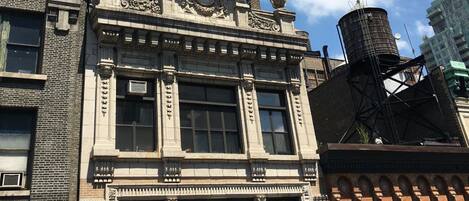 A historic building with ornate architectural details, large windows, and a fire escape.