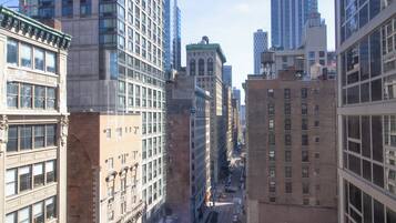A cityscape with tall buildings, a street with vehicles, and a clear sky.