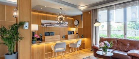Un salon moderne comprenant un canapé, une table basse et un coin repas avec des chaises et un comptoir de cuisine.