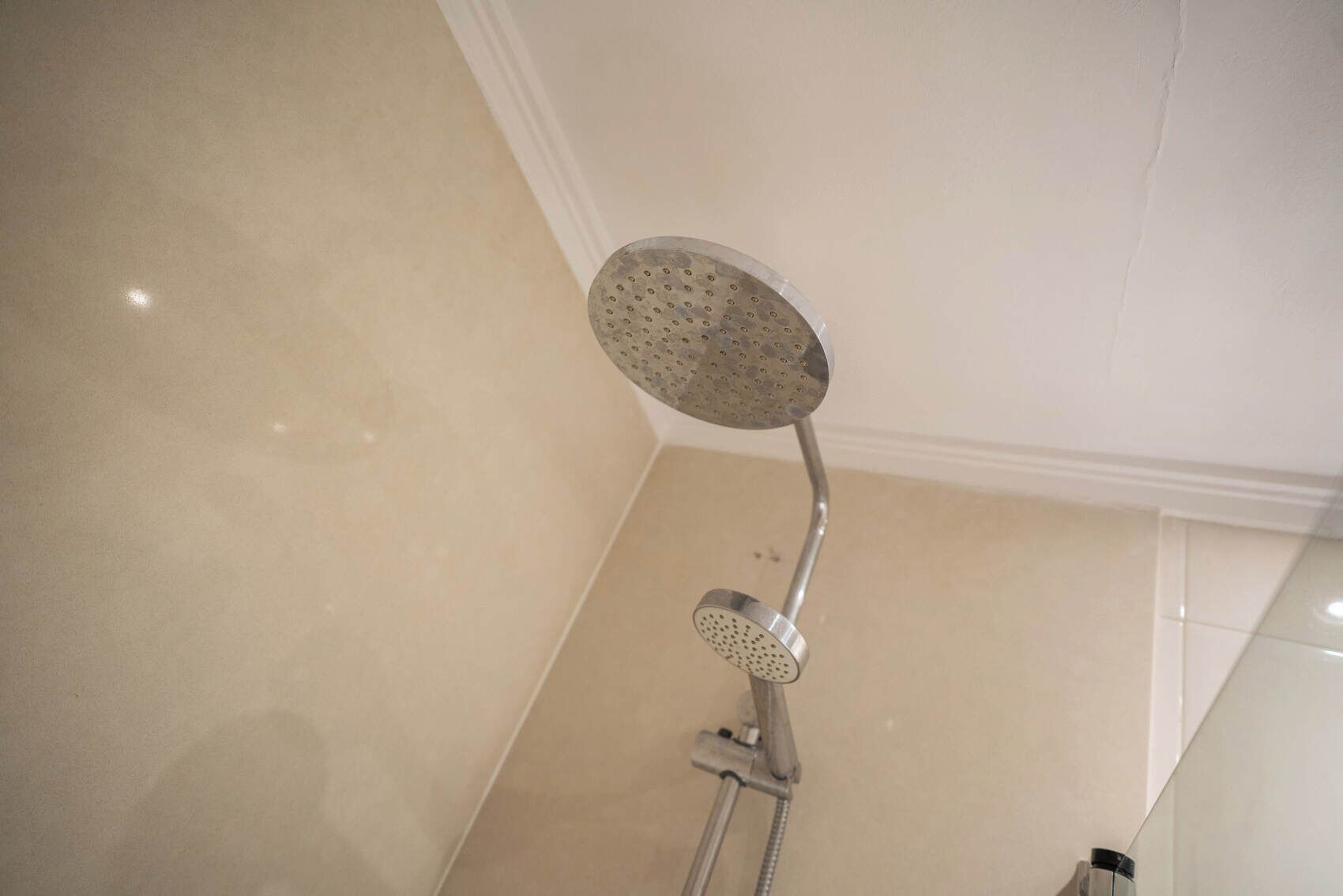 A showerhead with a circular head and a handheld attachment.