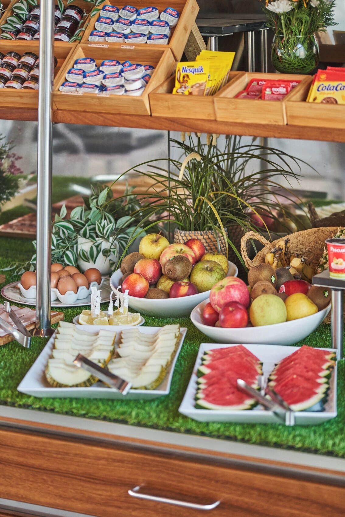 Ein Buffet mit verschiedenen Speisen, darunter Obst, Käse und Soßen.