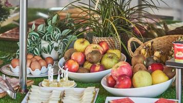 Ein Buffet mit verschiedenen Speisen, darunter Obst, Käse und Soßen.