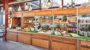 Un buffet composé de meubles en bois, d’un grill et de divers plats.