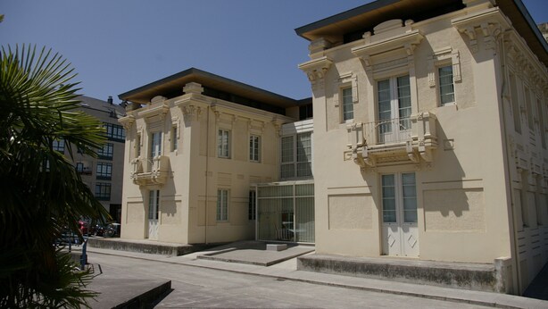 A building with classical architecture, featuring symmetrical windows and decorative moldings.