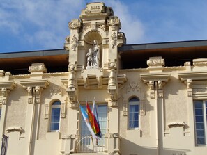A building with ornate architectural details, including a statue and flags. - Hotel Villa de Betanzos (Betanzos)