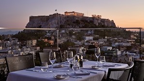 A table set for dining with a view of a historic building on a hill. - Electra Metropolis Athens (Athens)