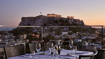 A table set for dining with a view of a historic building on a hill.
