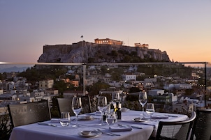 A table set for dining with a view of a historic building on a hill.