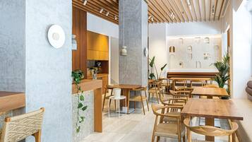 Ein modernes Interieur mit Holzmöbeln, einem Empfangsbereich und einer Wand mit geometrischen Ausschnitten.