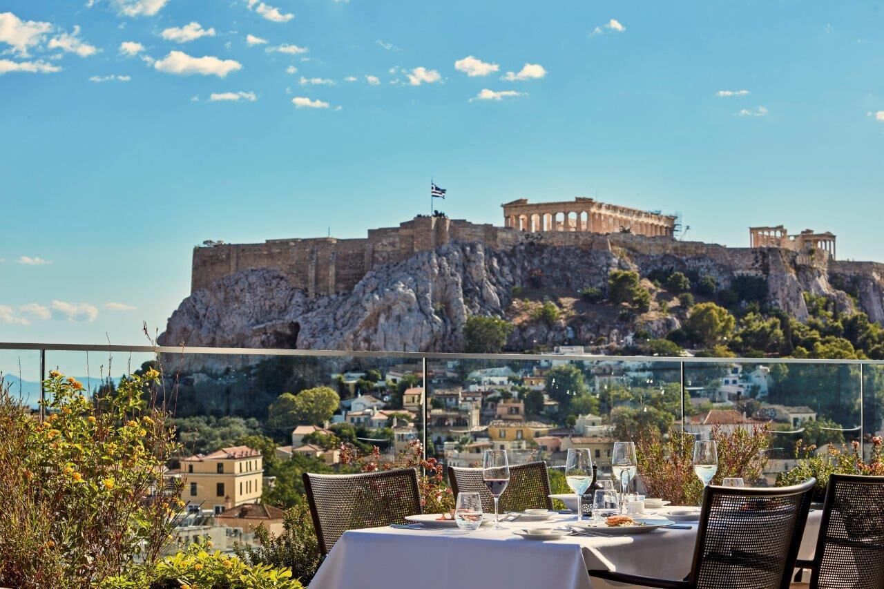 Un tavolo apparecchiato per la cena con vista su un'antica fortezza collinare.